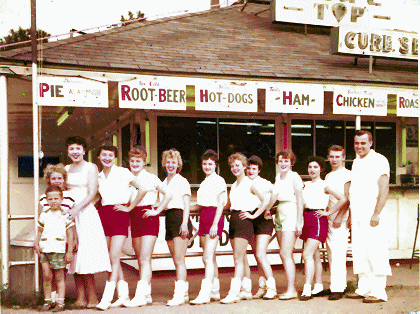 Johnsen family standing in front of blue top with employees 1956 or 1957